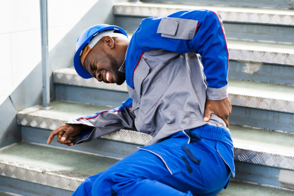man on stairs grabbing his back in pain